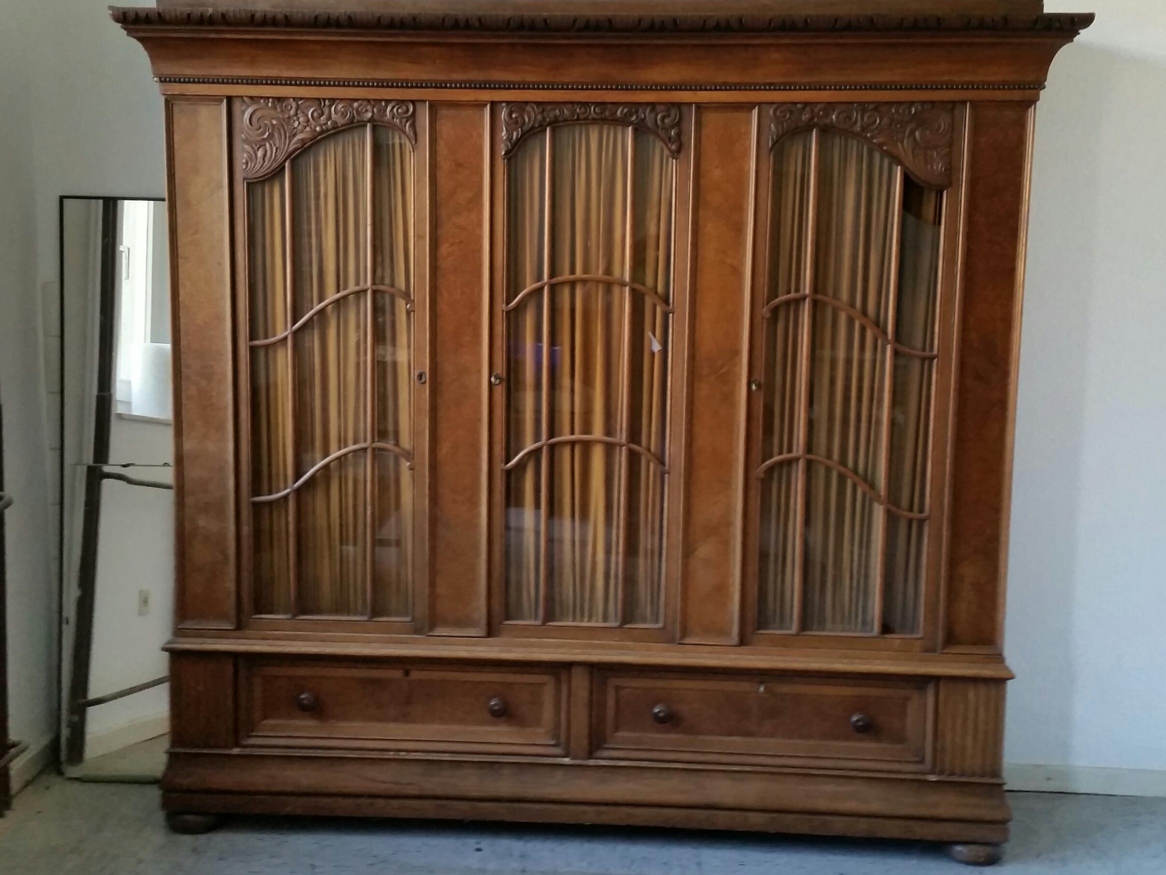 Dreitüriger Schrank aus dunklem Holz mit Glasscheiben