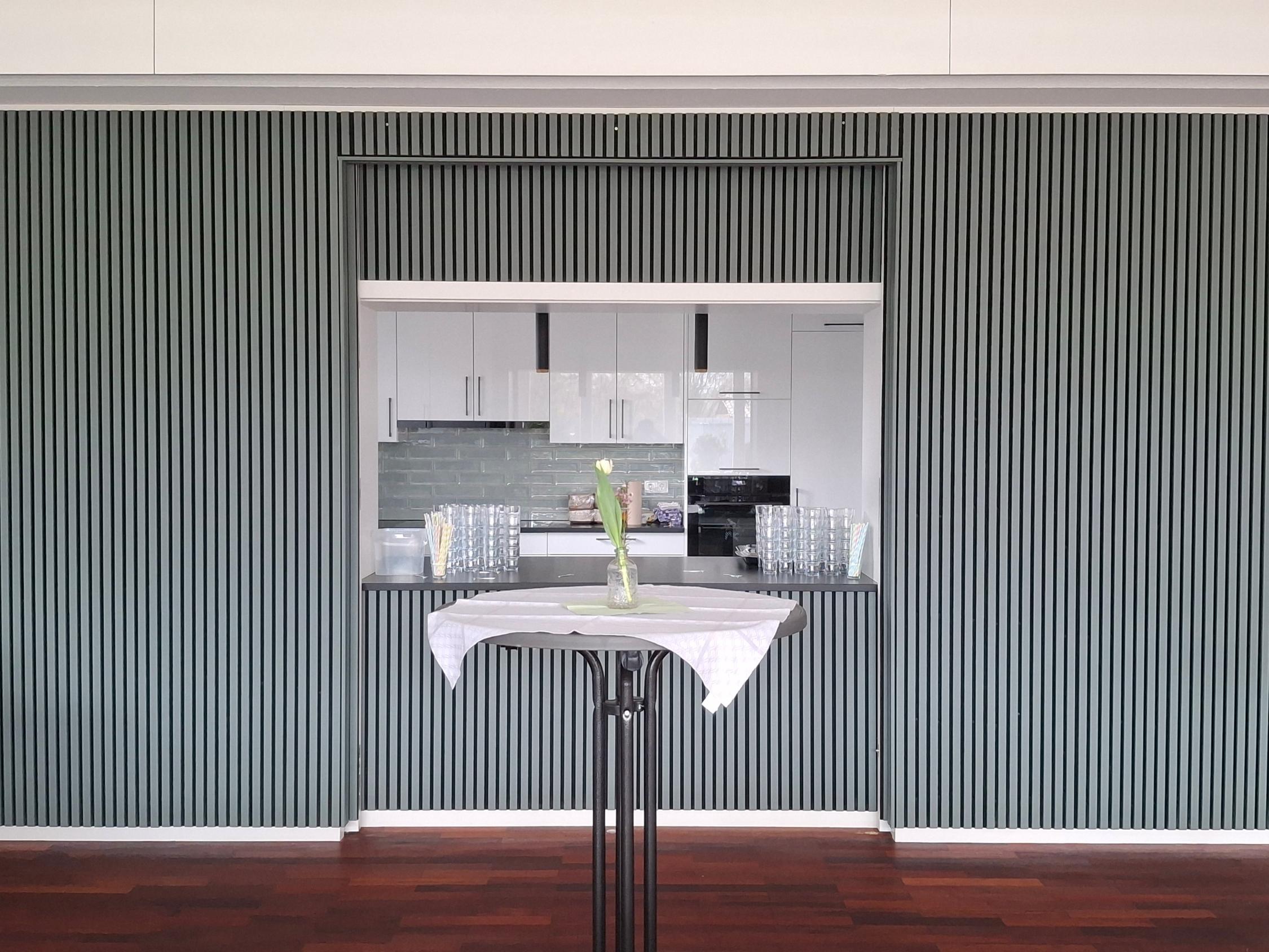 Blick durch die Durchreiche im Saal in die Küche