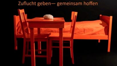 Ein Tisch mit Stühlen und ein Bett stehen in einem Raum