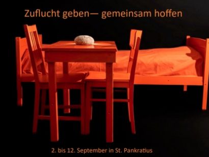 Ein Tisch mit Stühlen und ein Bett stehen in einem Raum